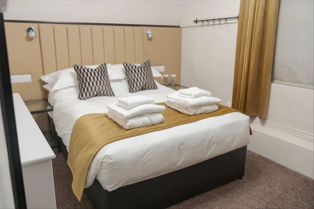 Double bed with towels and robes laid out